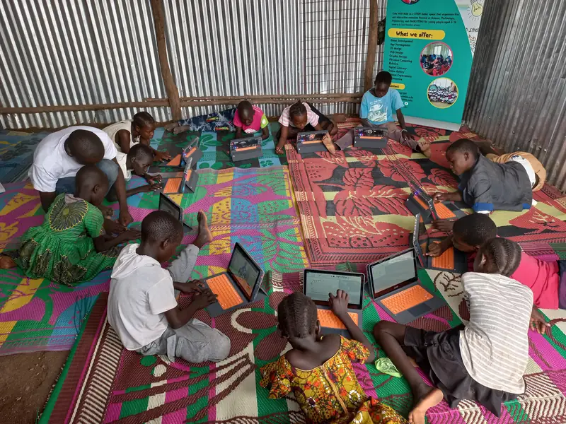 Children learning with tablets on classroom mats