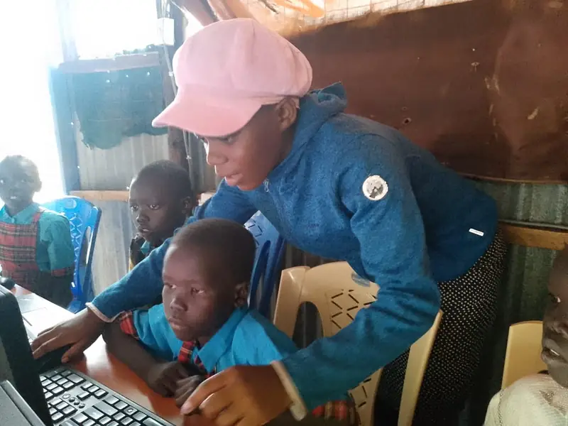 A teacher guiding a pupil on a computer