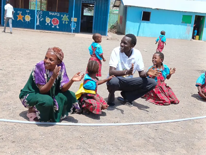Parents and teachers working together in a Light Academy classroom in Kalobeyei, Kenya