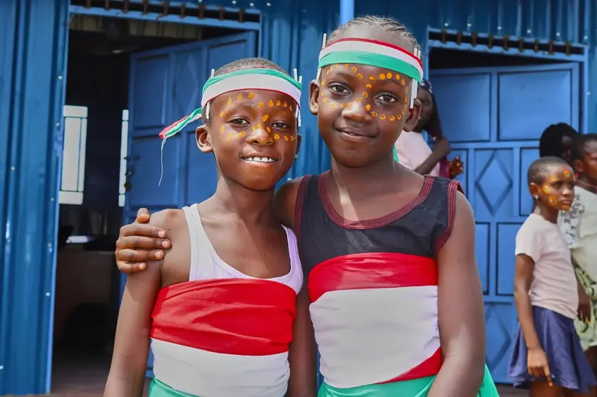 Two Light Academy pupils smiling together at a school celebration in Kalobeyei